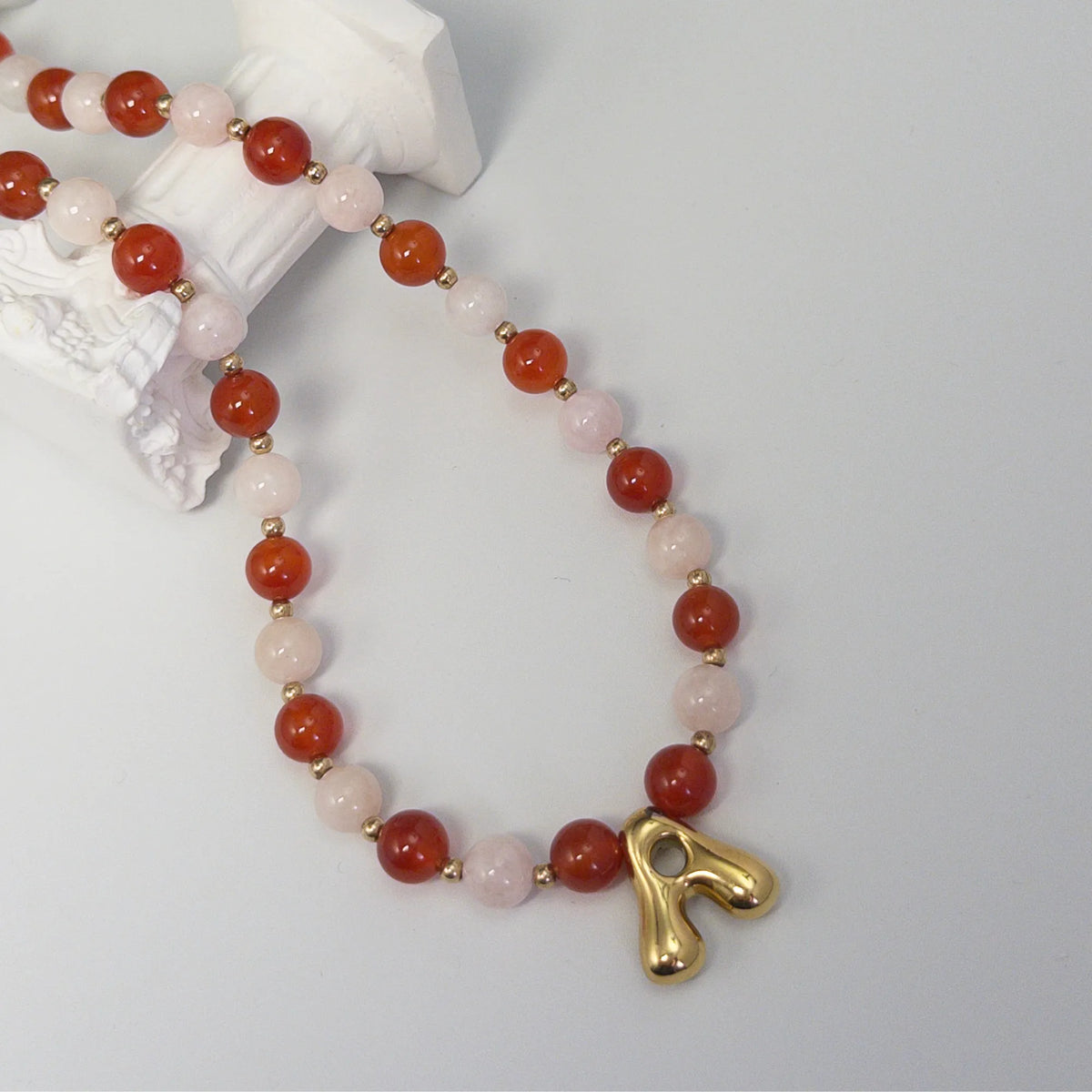 personalised 14K gold filled necklace with alternating carnelian and pink morganite beads, gold spacers and bubble initial letter.
