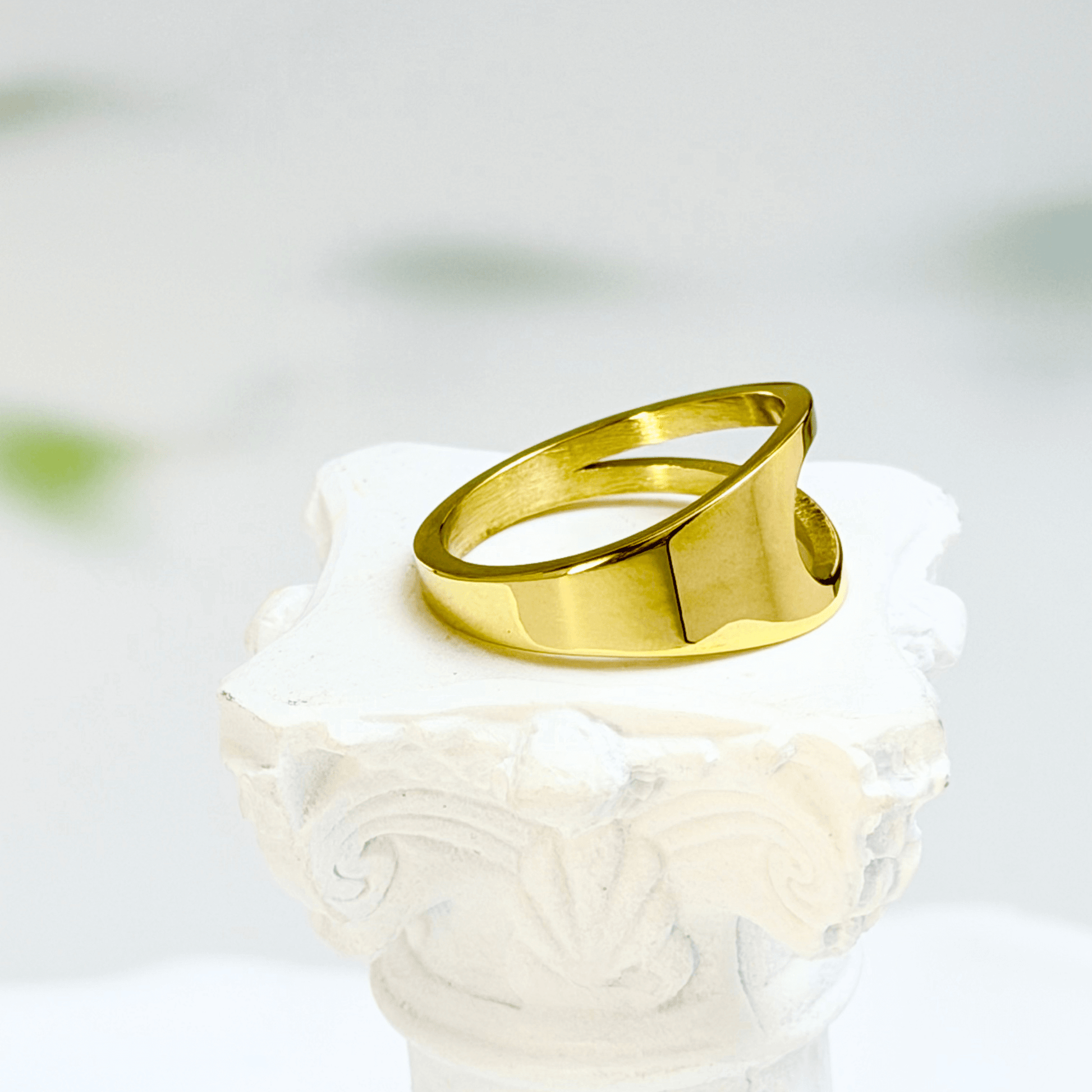 gold carved arc ring on white background, minimal sculptural gold ring