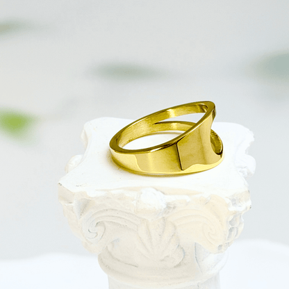 gold carved arc ring on white background, minimal sculptural gold ring