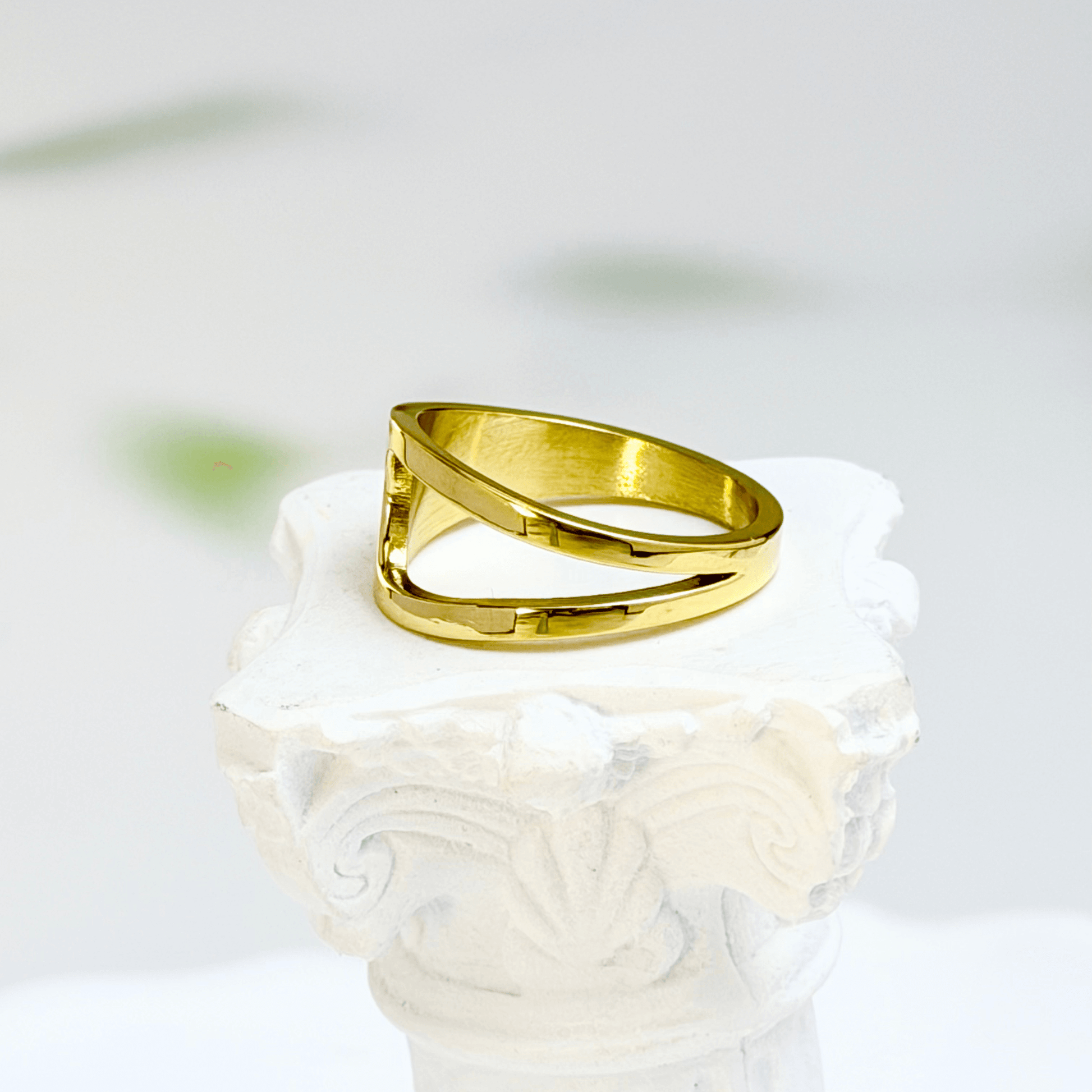 gold carved arc ring on white background, minimal sculptural gold ring
