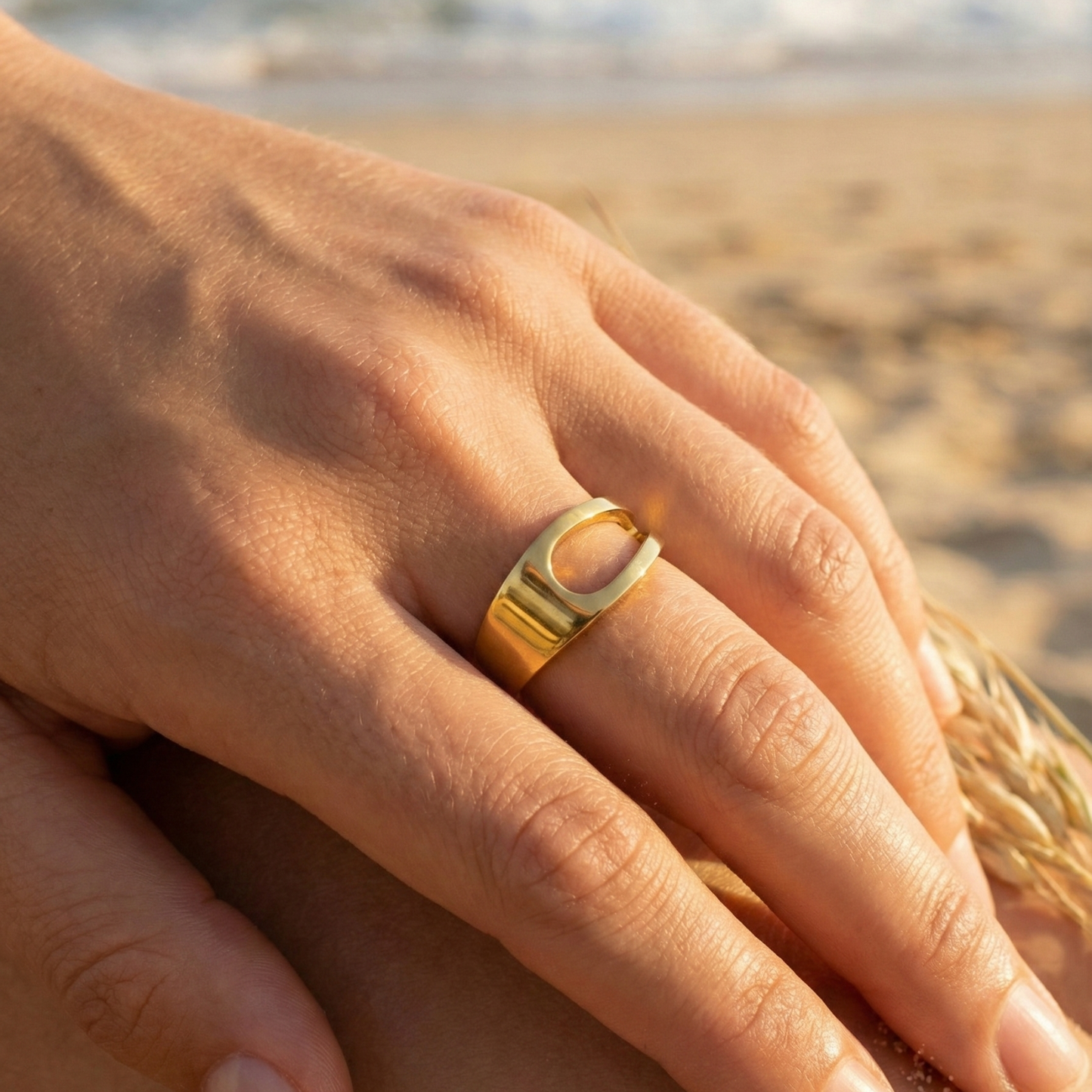 gold carved arc ring on white background, minimal sculptural gold ring