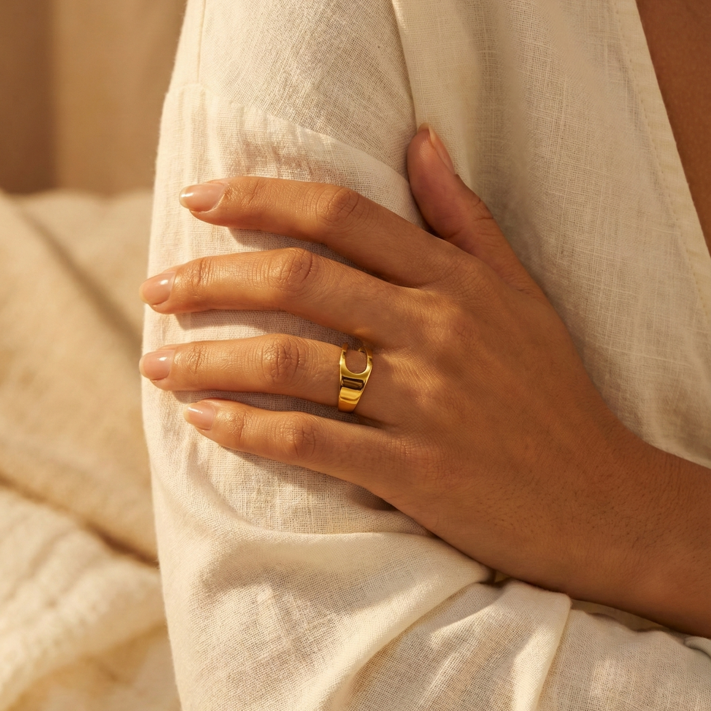 gold carved arc ring on white background, minimal sculptural gold ring
