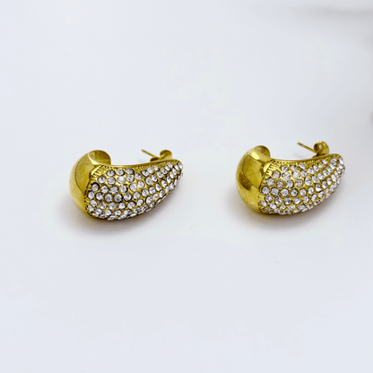 Chunky pavé gold half hoop earrings with crystal detailing, photographed on a clean light background.