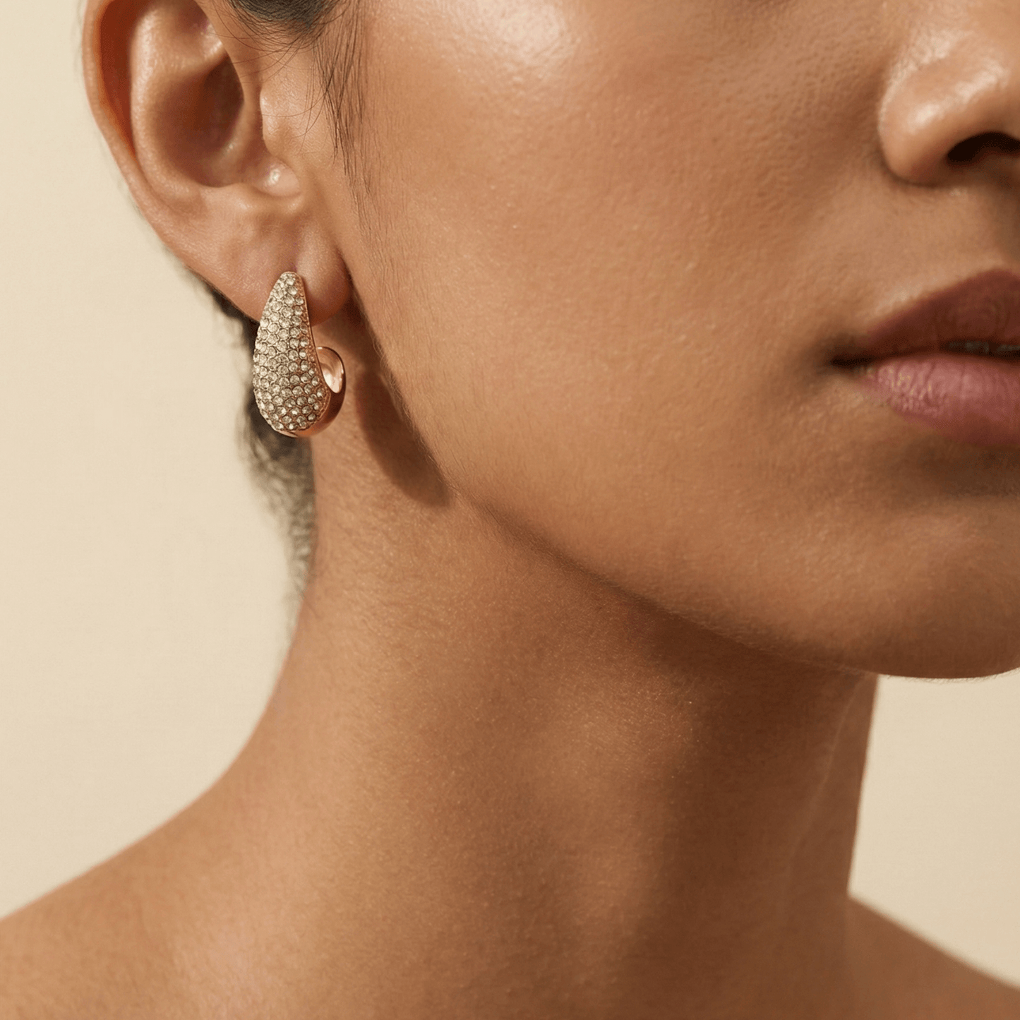 Chunky pavé gold half hoop earrings with crystal detailing, photographed on a clean light background.