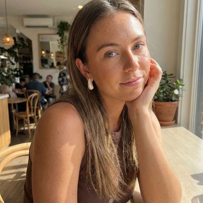 Chunky pavé gold half hoop earrings with crystal detailing, photographed on a clean light background.