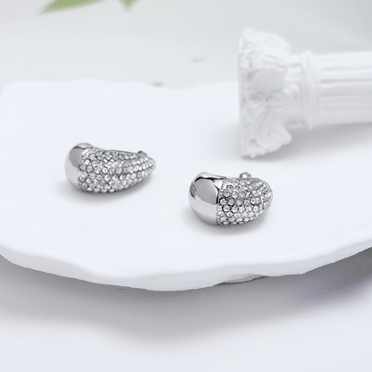 Chunky pavé silver half hoop earrings with crystal detailing, photographed on a light background.