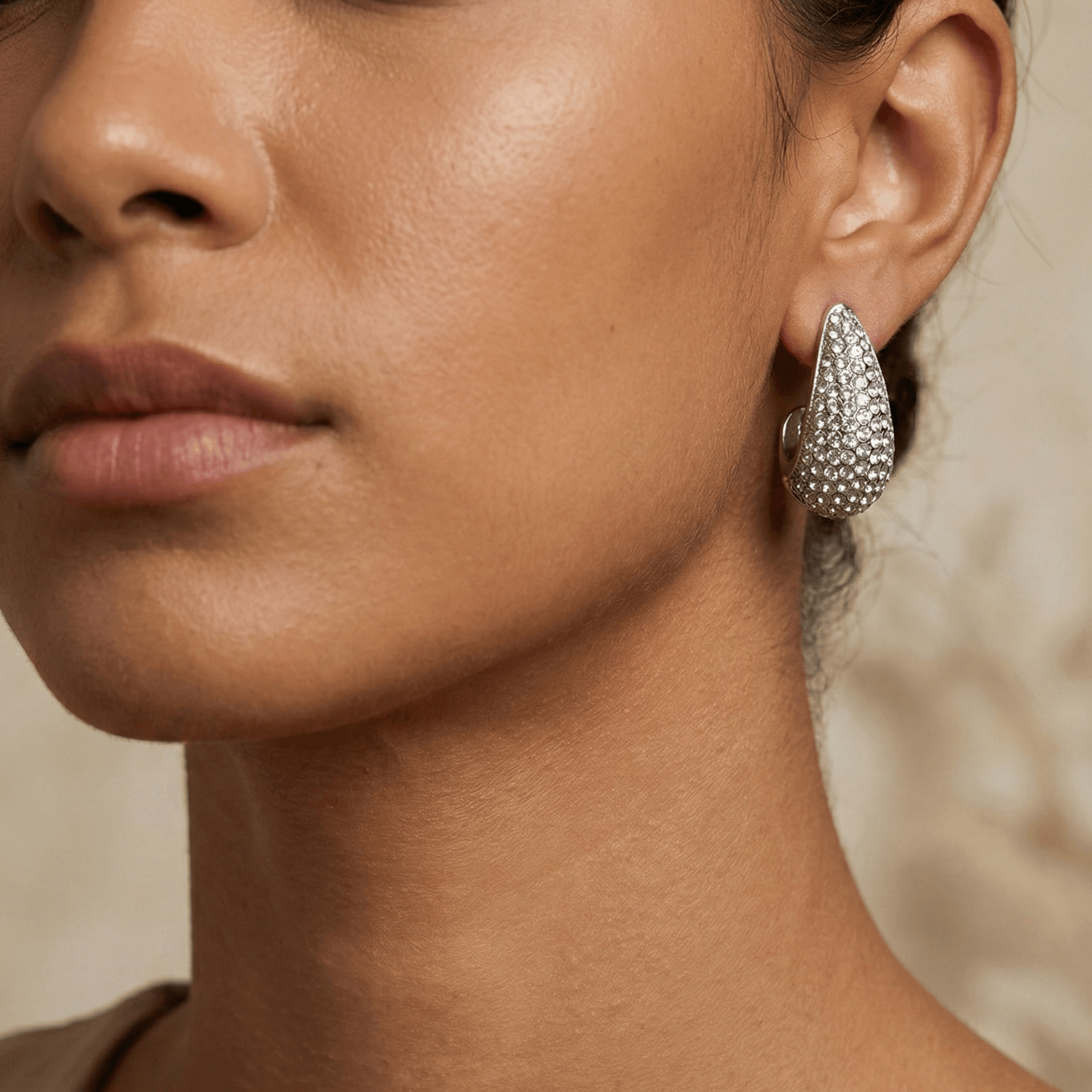Chunky pavé silver half hoop earrings with crystal detailing, photographed on a light background.
