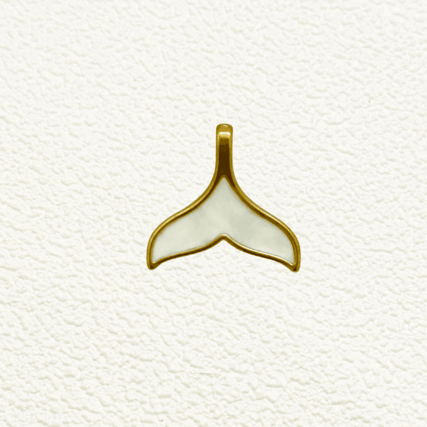 Gold and white enamel whale tail charm with smooth, glossy finish – nautical pendant