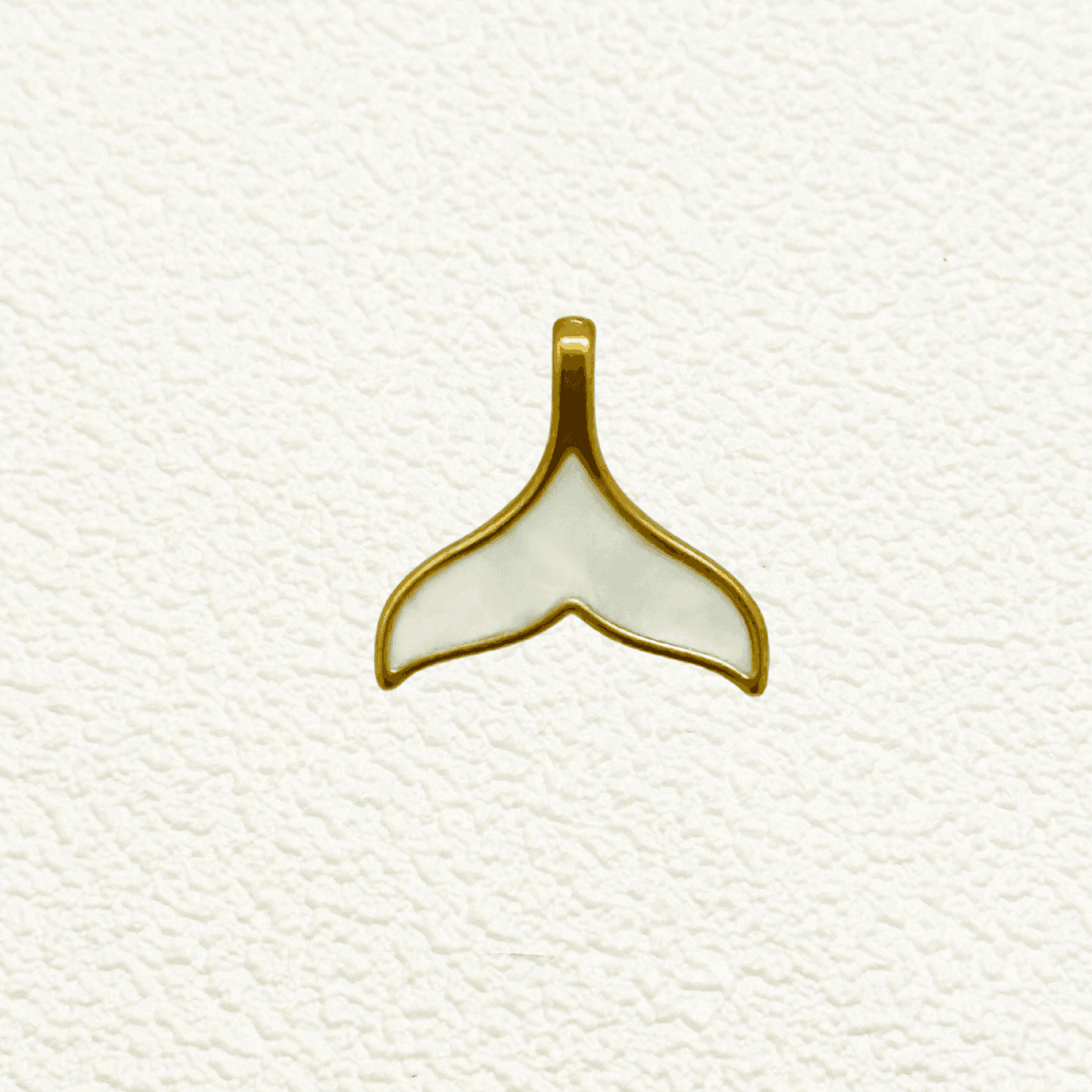 Gold and white enamel whale tail charm with smooth, glossy finish – nautical pendant