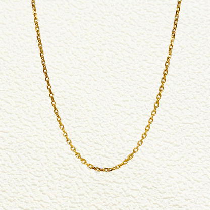 Gold cable chain made of fine interlocking links in a classic minimalist style, available as necklace, bracelet, or anklet