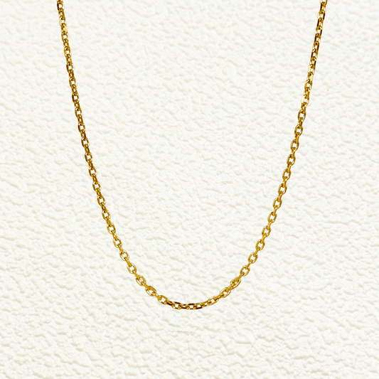 Gold cable chain made of fine interlocking links in a classic minimalist style, available as necklace, bracelet, or anklet