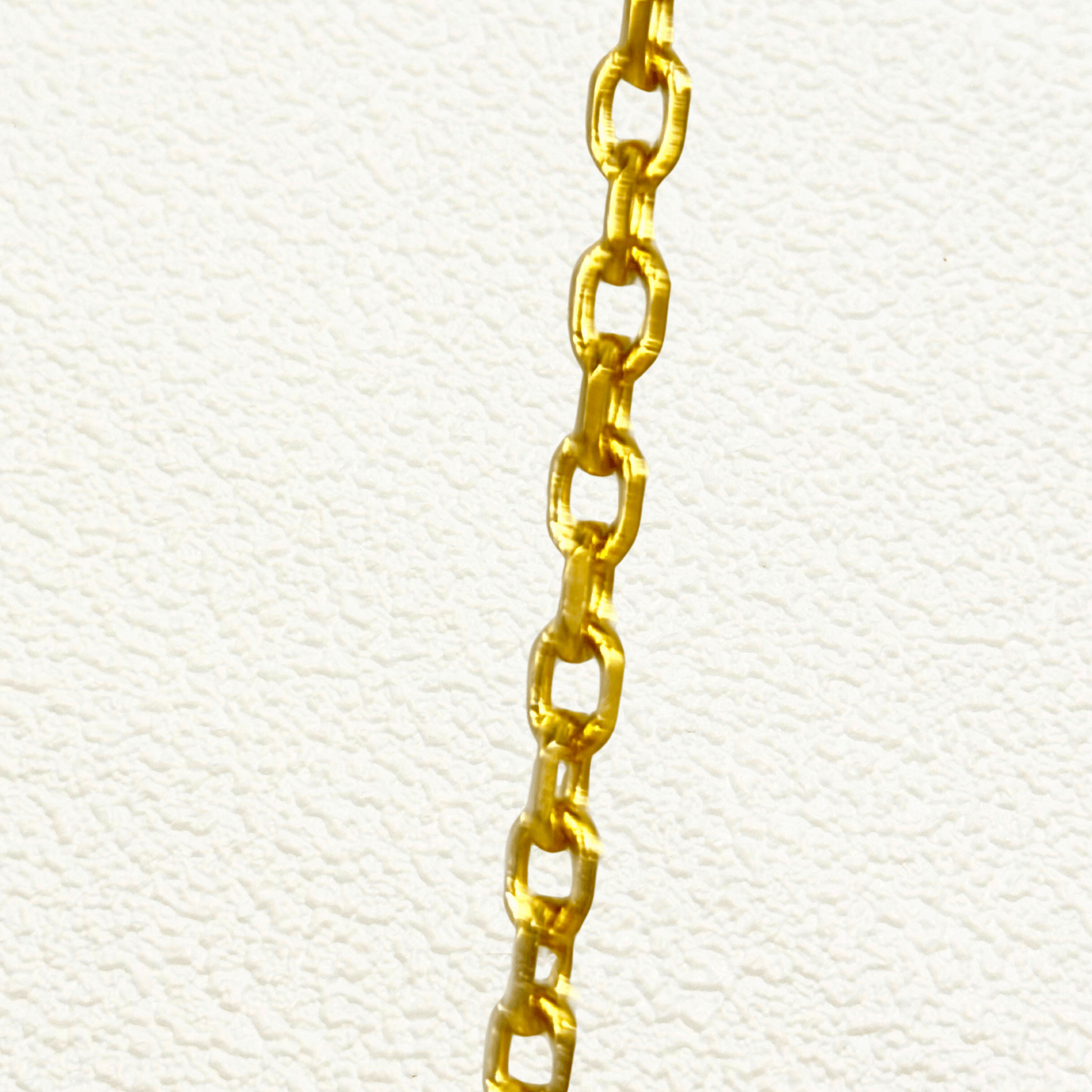 Gold cable chain made of fine interlocking links in a classic minimalist style, available as necklace, bracelet, or anklet