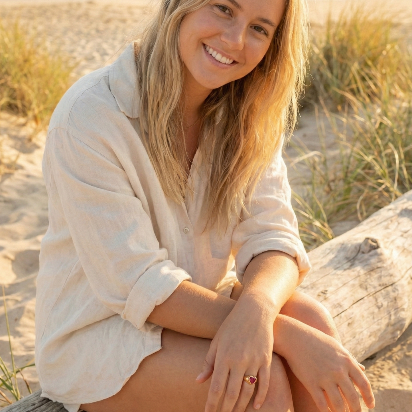 gold signet ring with a red heart-shaped stone in the centre