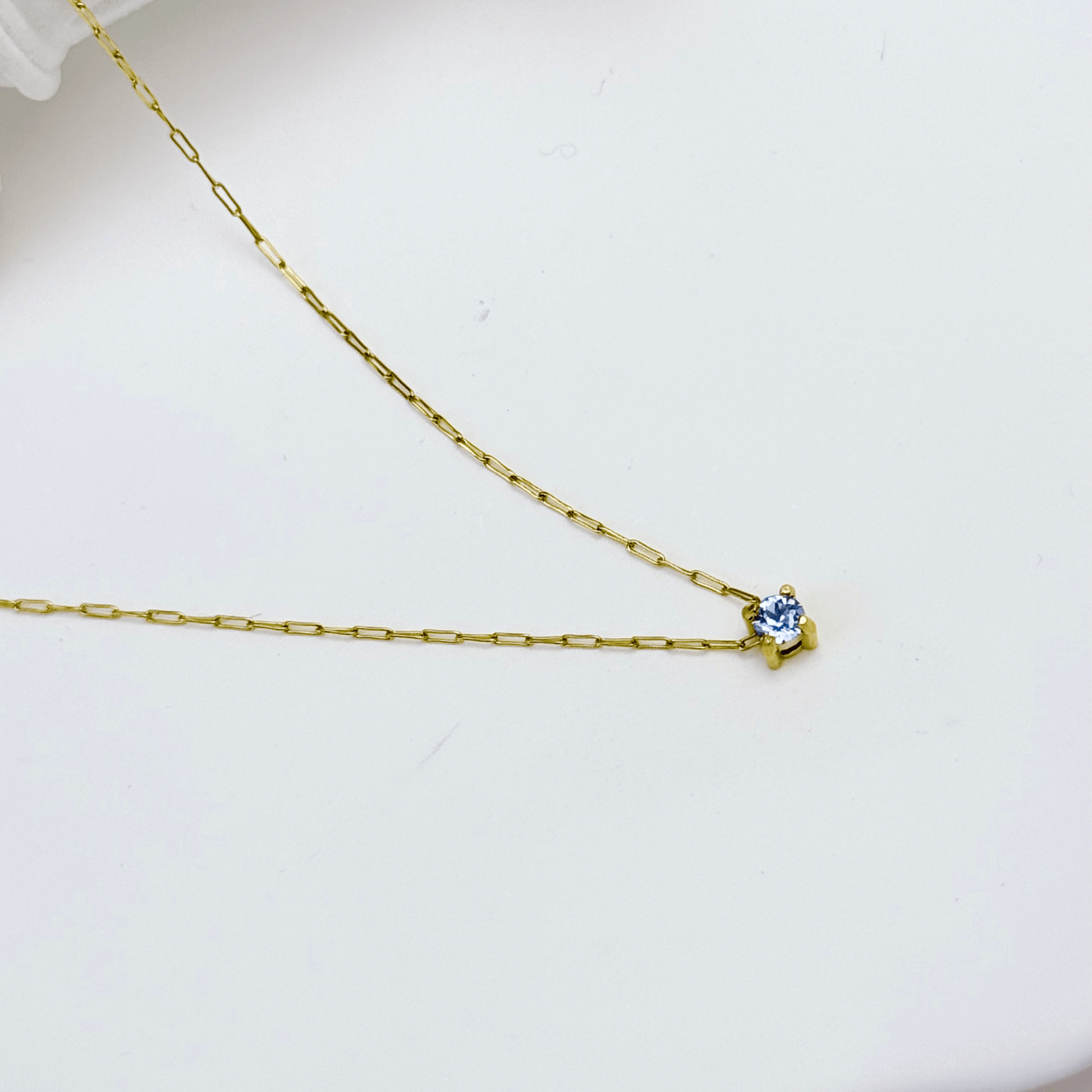 Dainty gold birthstone necklace with sparkling Swarovski element, minimalist and elegant design for everyday wear.