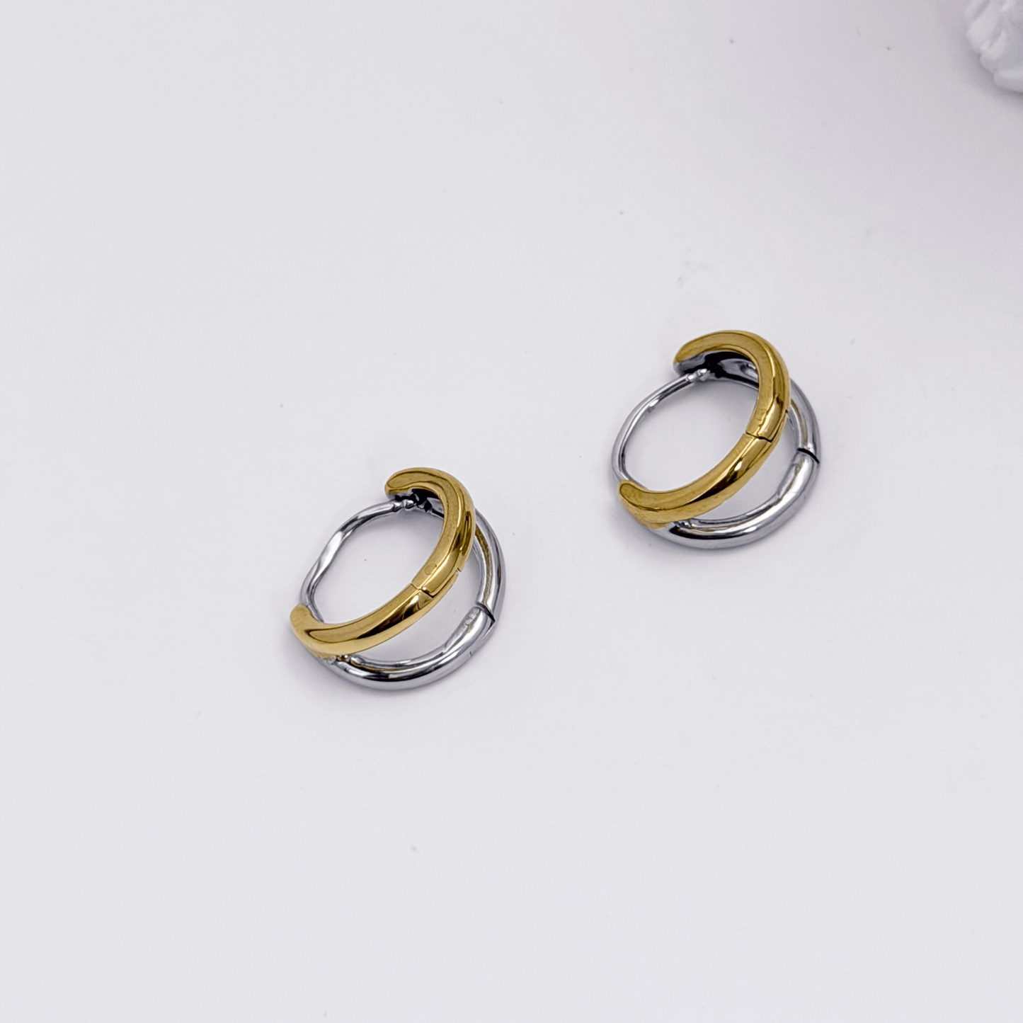Dual-tone gold and silver huggie earrings with polished modern design
