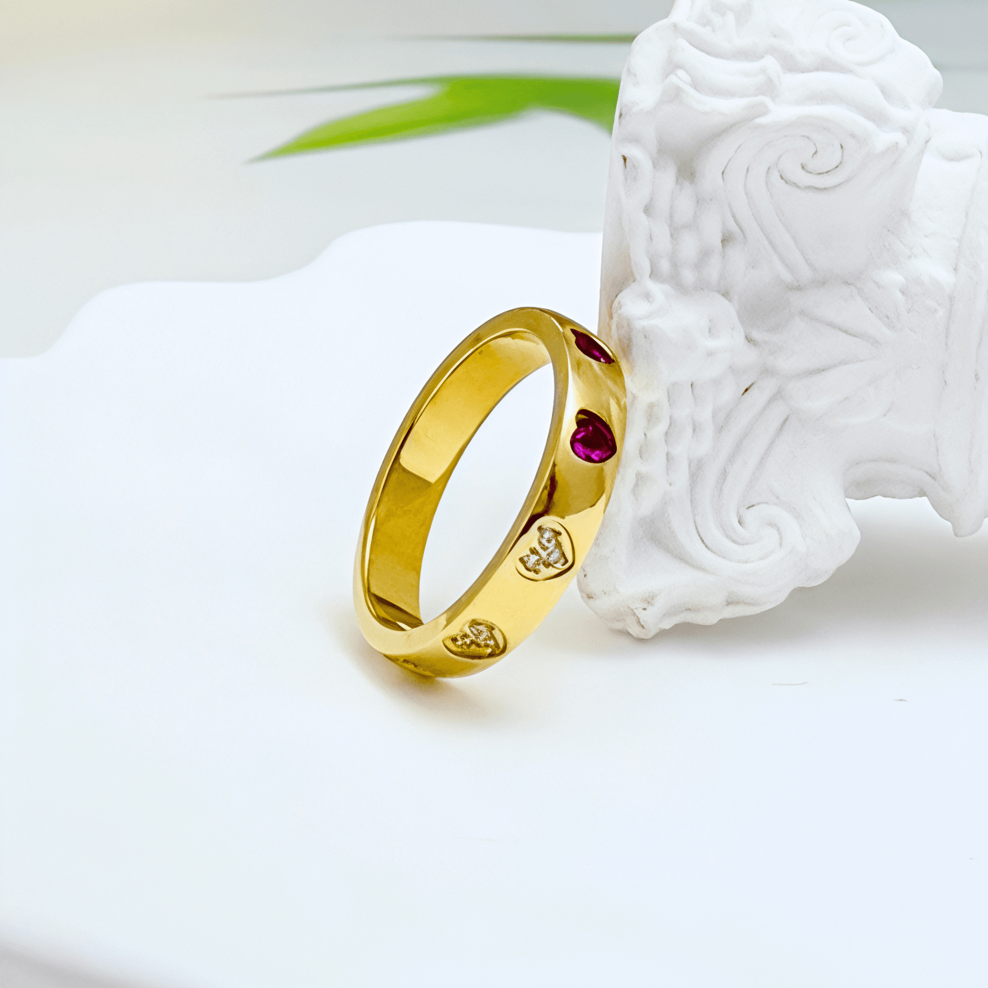 Gold waterproof ring with alternating pink and clear heart-shaped stones.