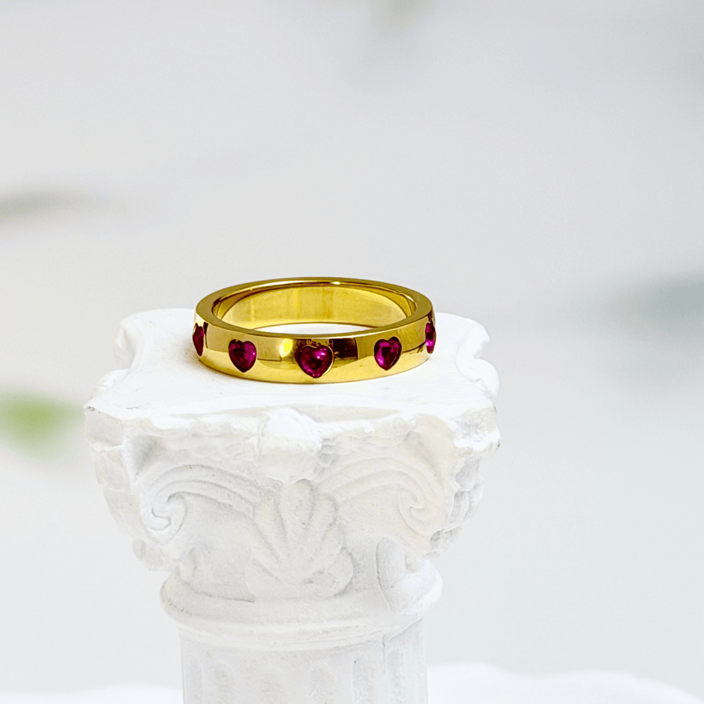 Gold waterproof ring with alternating pink and clear heart-shaped stones.