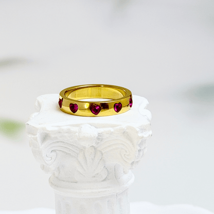 Gold waterproof ring with alternating pink and clear heart-shaped stones.