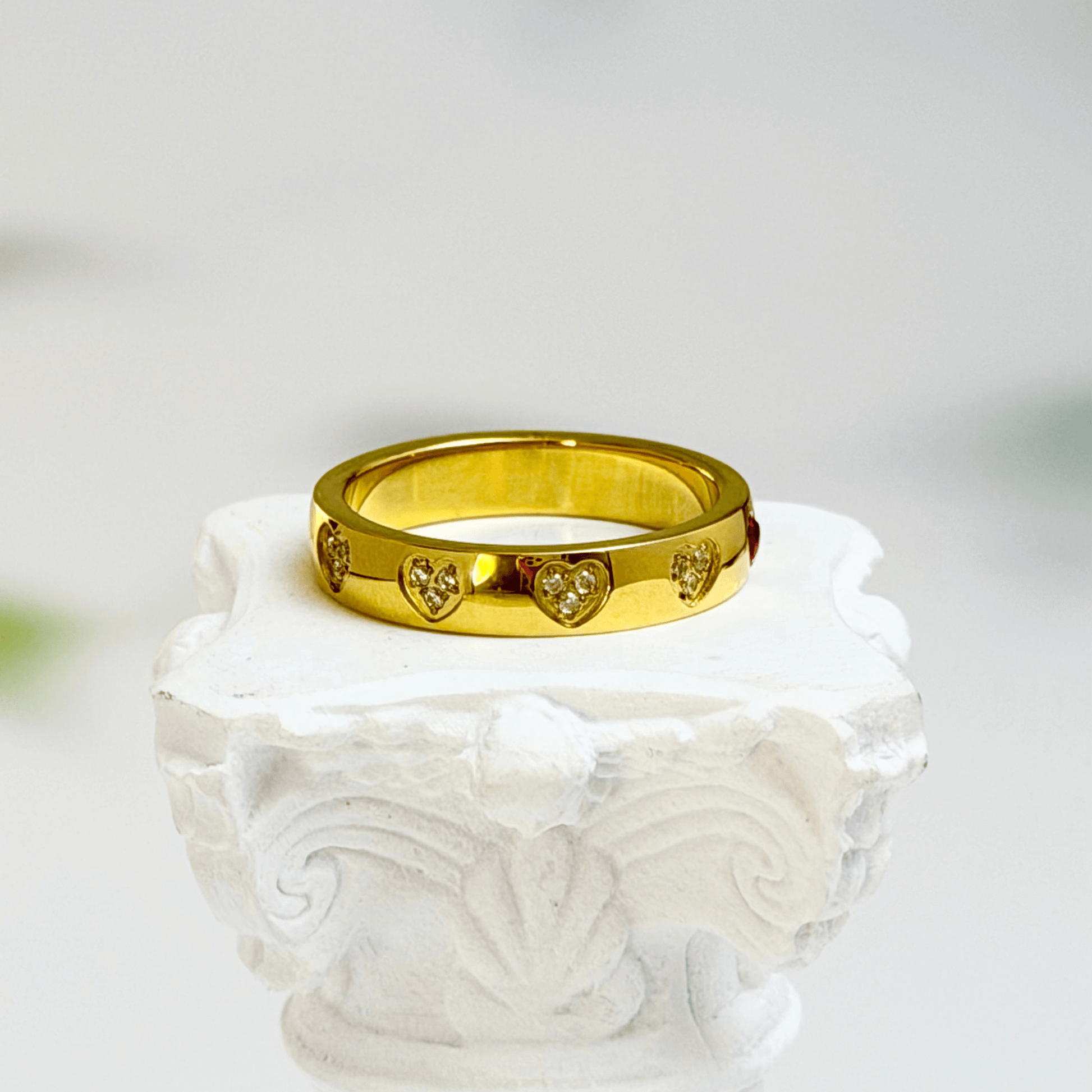 Gold waterproof ring with alternating pink and clear heart-shaped stones.
