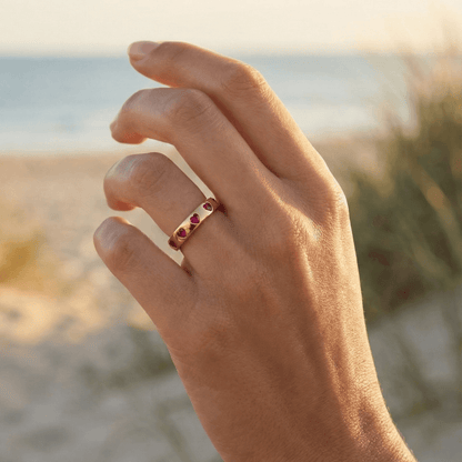 Gold waterproof ring with alternating pink and clear heart-shaped stones.