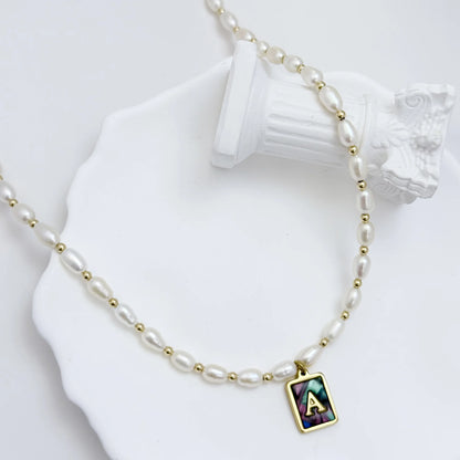 Premium freshwater rice pearl and 14K gold filled beaded necklace with personalised abalone shell initial charm, hand-finished in Australia