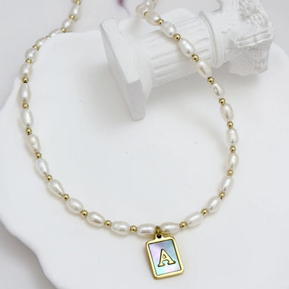 Premium freshwater rice pearl and 14K gold filled beaded necklace with personalised blue mother of shell initial charm, hand-finished in Australia