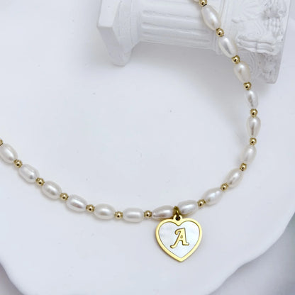Premium freshwater rice pearl and 14K gold filled beaded necklace with personalised heart shaped mother of shell initial charm, hand-finished in Australia
