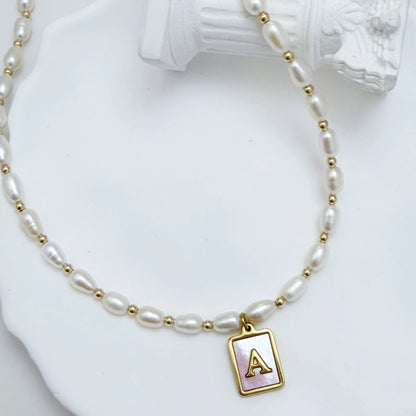 Premium freshwater rice pearl and 14K gold filled beaded necklace with personalised pink mother of shell initial charm, hand-finished in Australia