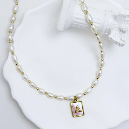 Premium freshwater rice pearl and 14K gold filled beaded necklace with personalised pink mother of shell initial charm, hand-finished in Australia