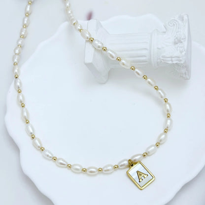 Premium freshwater rice pearl and 14K gold filled beaded necklace with personalised mother of shell initial charm, hand-finished in Australia