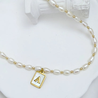 Premium freshwater rice pearl and 14K gold filled beaded necklace with personalised mother of shell initial charm, hand-finished in Australia