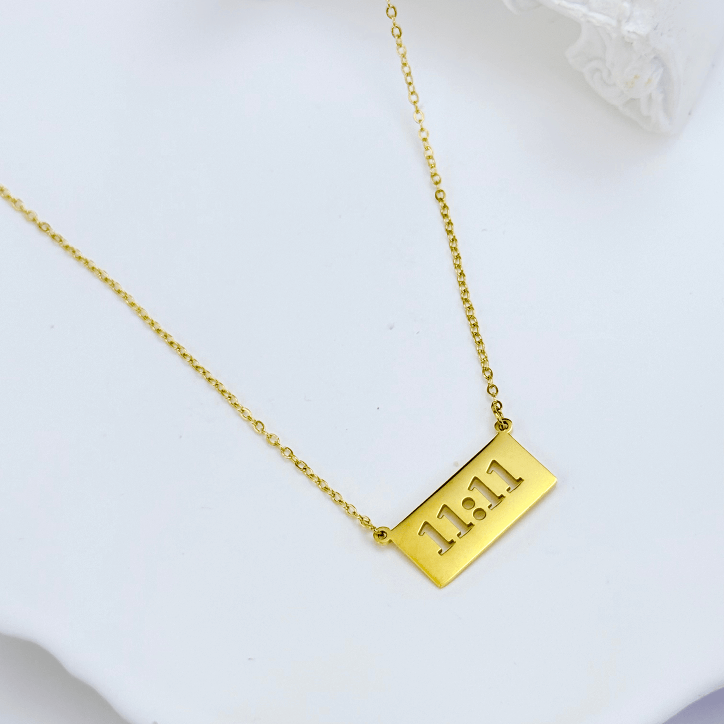 Gold 11:11 angel number necklace featuring a rectangular pendant on a dainty chain, symbolising manifestation and alignment.