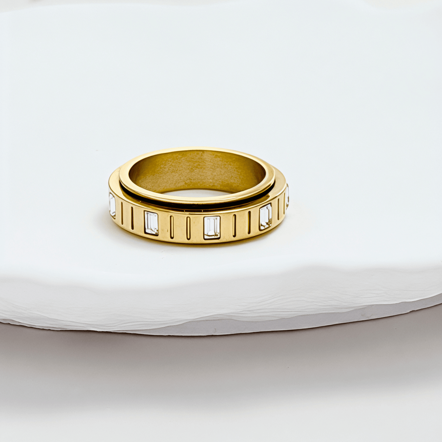 Gold Baguette Spinner Ring by MXW Jewellery featuring a rotating band set with clear rectangular crystals.