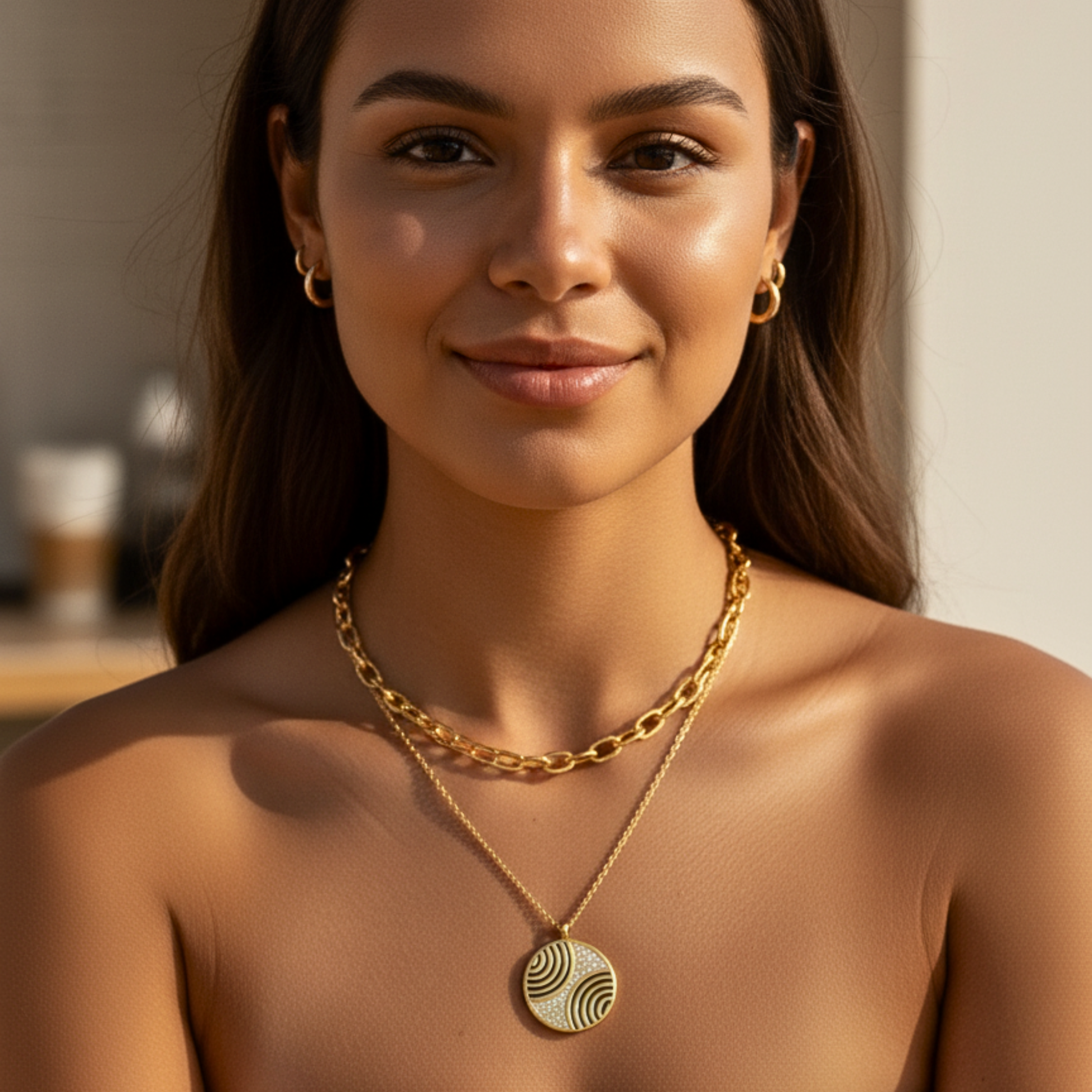 Gold round pendant necklace with engraved flowing pattern and crystal detailing, symbolising harmony and balance.