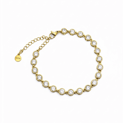 Gold crystal tennis bracelet with bezel-set clear stones.
