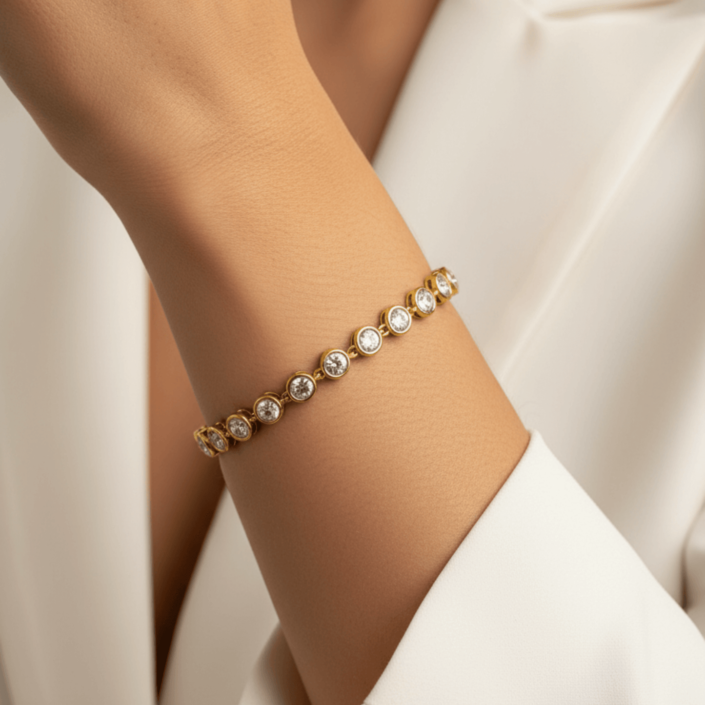 Gold crystal tennis bracelet with bezel-set clear stones.