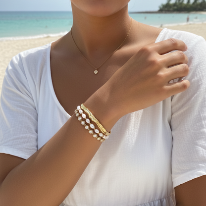 Gold crystal tennis bracelet with bezel-set clear stones.