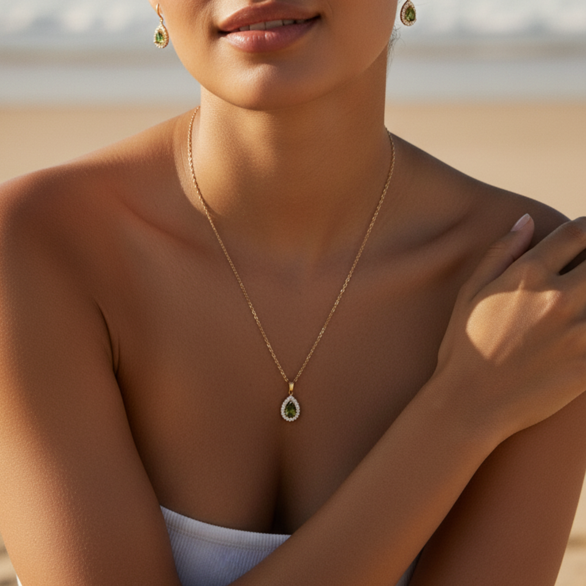 gold emerald glow teardrop necklace with green gemstone surrounded by clear crystals on gold chain