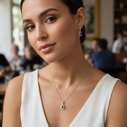 gold emerald glow teardrop necklace with green gemstone surrounded by clear crystals on gold chain