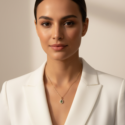gold emerald glow teardrop necklace with green gemstone surrounded by clear crystals on gold chain