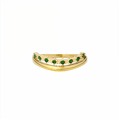 Gold curved stacking ring with emerald green crystals on white pedestal MXW Jewellery
