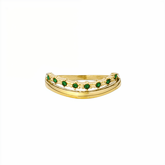Gold curved stacking ring with emerald green crystals on white pedestal MXW Jewellery