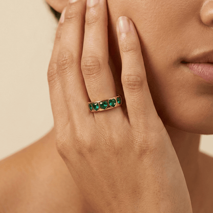 Gold Emerald Green Heart Ring by MXW Jewellery featuring a chunky gold band with flush-set emerald-hued heart stones