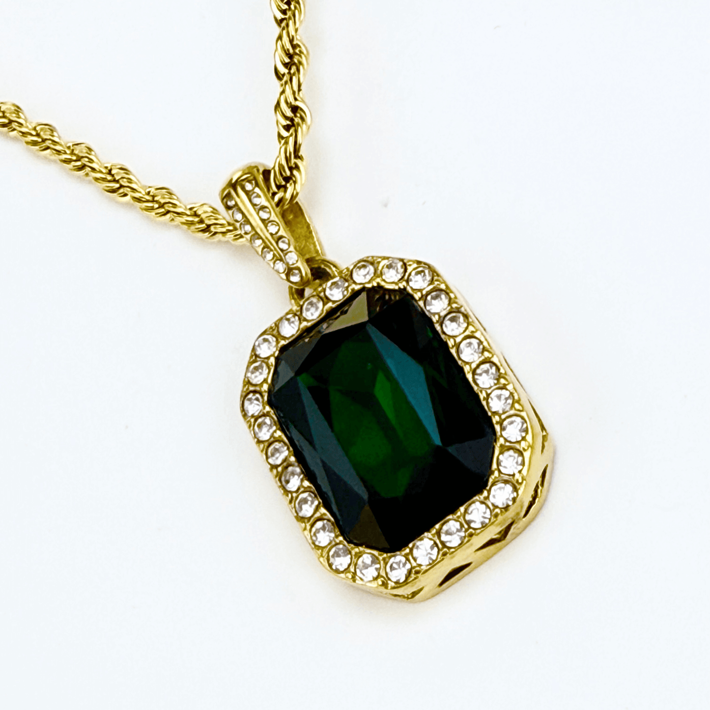 Gold emerald halo necklace featuring rectangular green zircon pendant on gold rope chain.