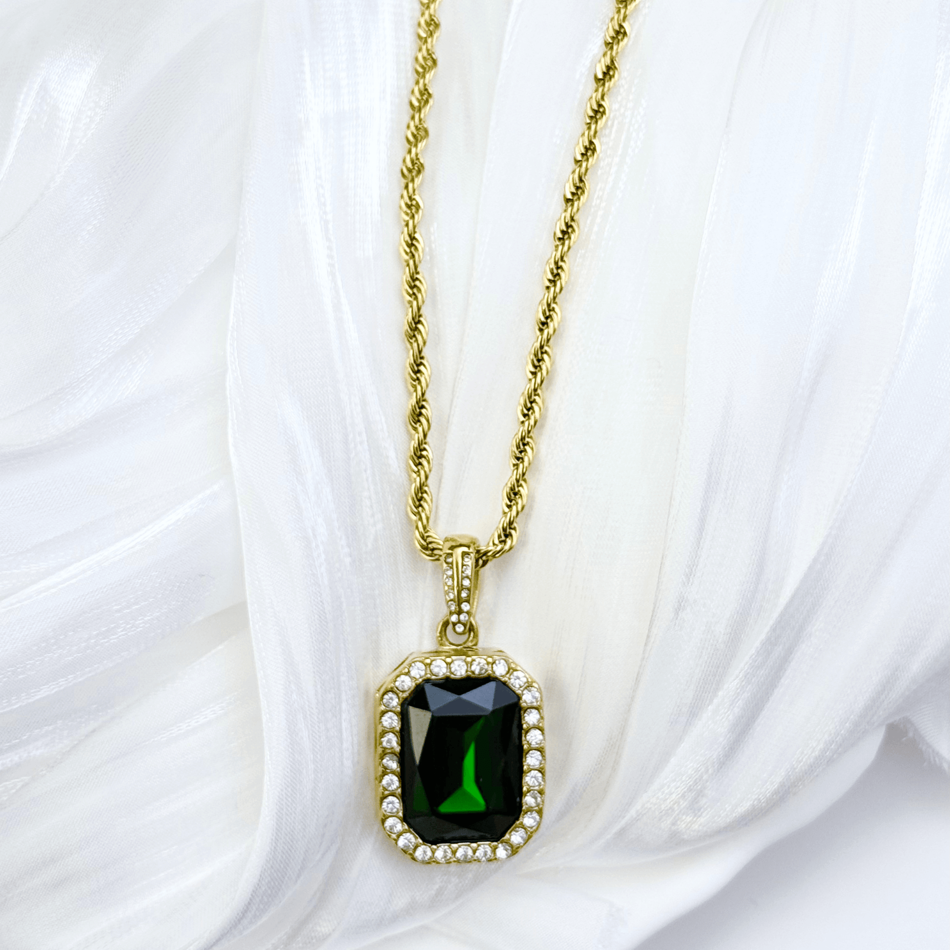 Gold emerald halo necklace featuring rectangular green zircon pendant on gold rope chain.