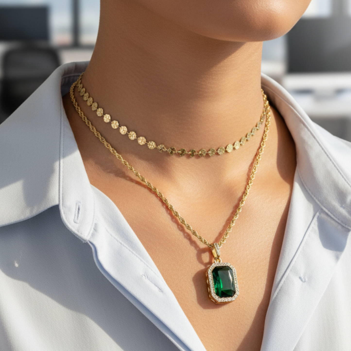 Gold emerald halo necklace featuring rectangular green zircon pendant on gold rope chain.