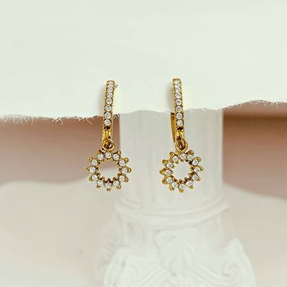 Gold huggie earrings featuring a pave crystal open circle charm dangling from a crystal hoop by MXW Jewellery