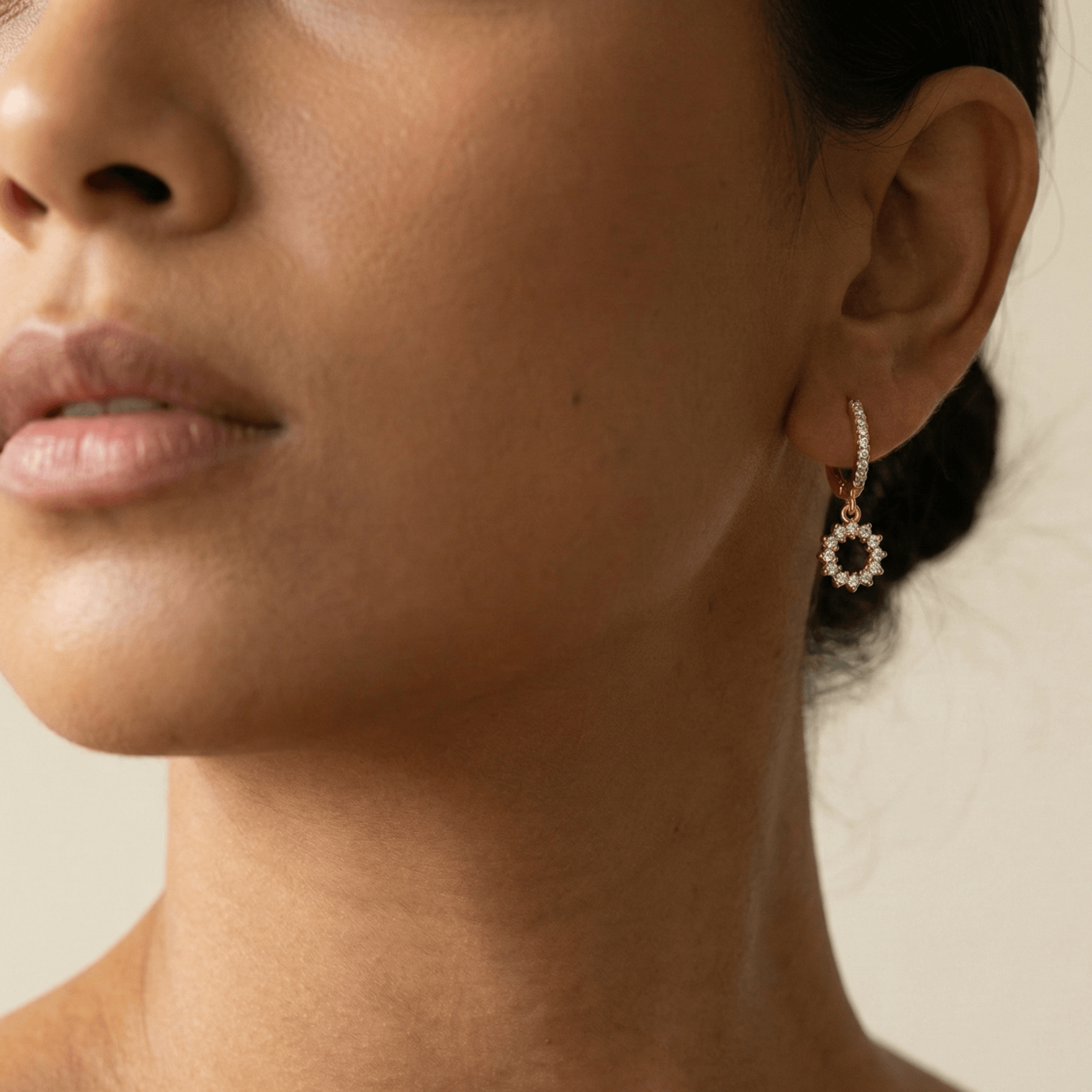 Gold huggie earrings featuring a pave crystal open circle charm dangling from a crystal hoop by MXW Jewellery