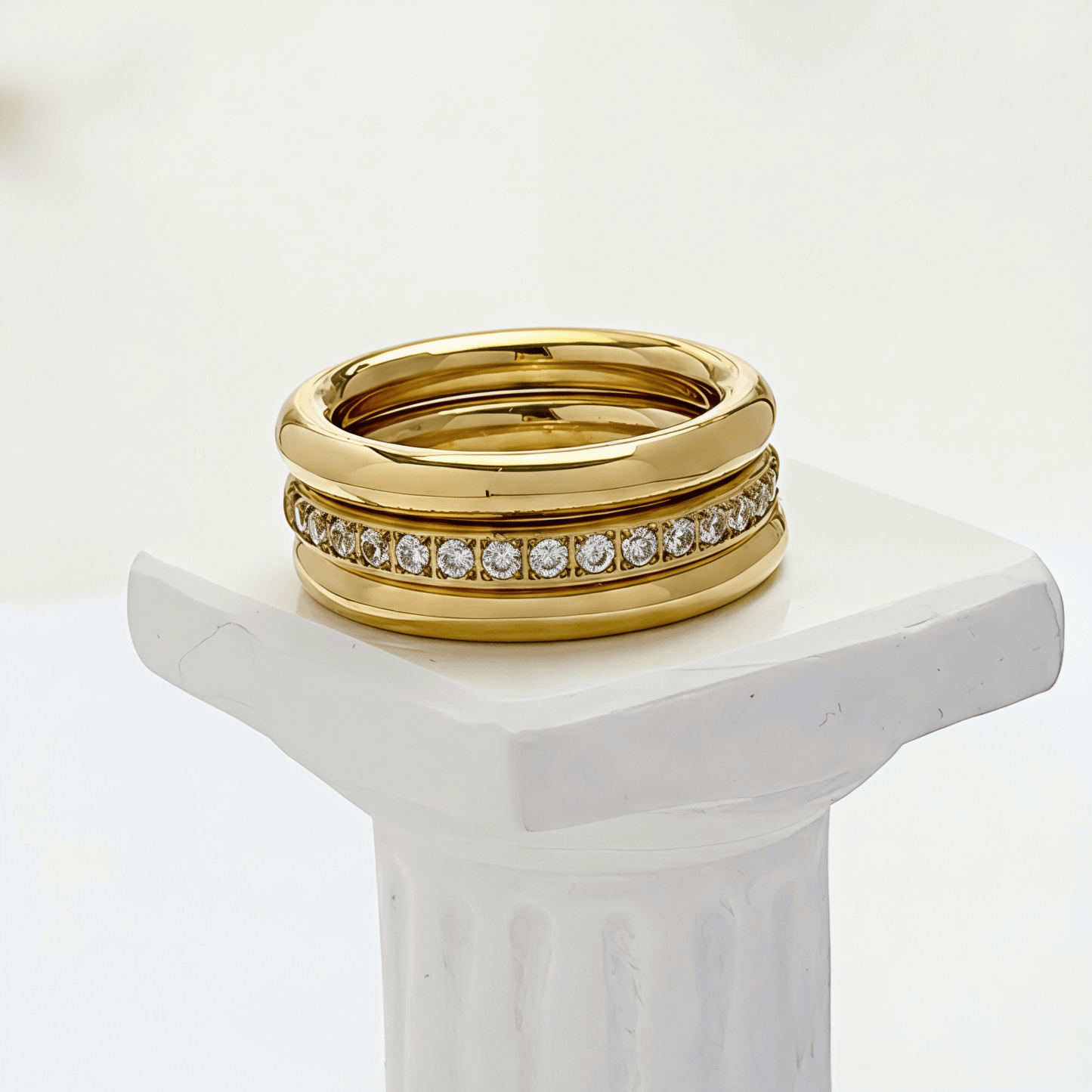 Close up of Gold Eternity Trio Stacking Ring Set by MXW Jewellery featuring a central crystal band nestled between two smooth gold bands.