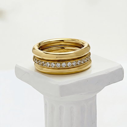 Close up of Gold Eternity Trio Stacking Ring Set by MXW Jewellery featuring a central crystal band nestled between two smooth gold bands.